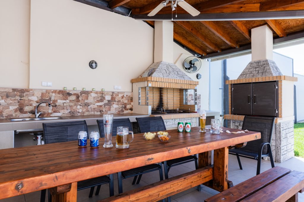 Σκεπασμένος χώρος BBQ στη Villa Memories στην Κινέτα με μεγάλο τραπέζι και ψησταριά