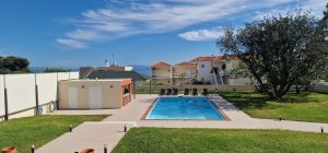 Εξωτερική άποψη της Villa Memories με την πισίνα, τις ξαπλώστρες και τον περιβάλλοντα κήπο