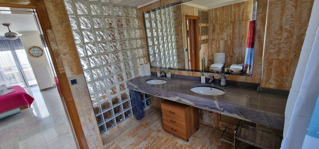 Ευρύχωρο μπάνιο στη Villa Memories στην Κινέτα με διπλό νιπτήρα, μεγάλο καθρέπτη και διακοσμητικά υαλότουβλα