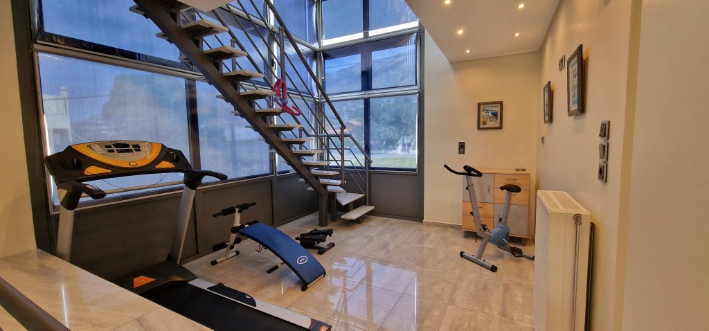Χώρος fitness στη Villa Memories στην Κινέτα με στατικό ποδήλατο και πάγκο ασκήσεων