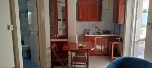 Εσωτερικός χώρος της Villa Memories στην Κινέτα με τραπέζι φαγητού και εξοπλισμένη κουζίνα