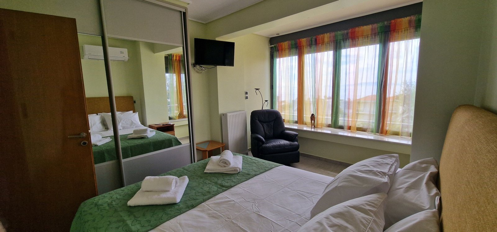 Υπνοδωμάτιο στη Villa Memories στην Κινέτα με διπλό κρεβάτι, πράσινη κουβέρτα και μεγάλο παράθυρο-4