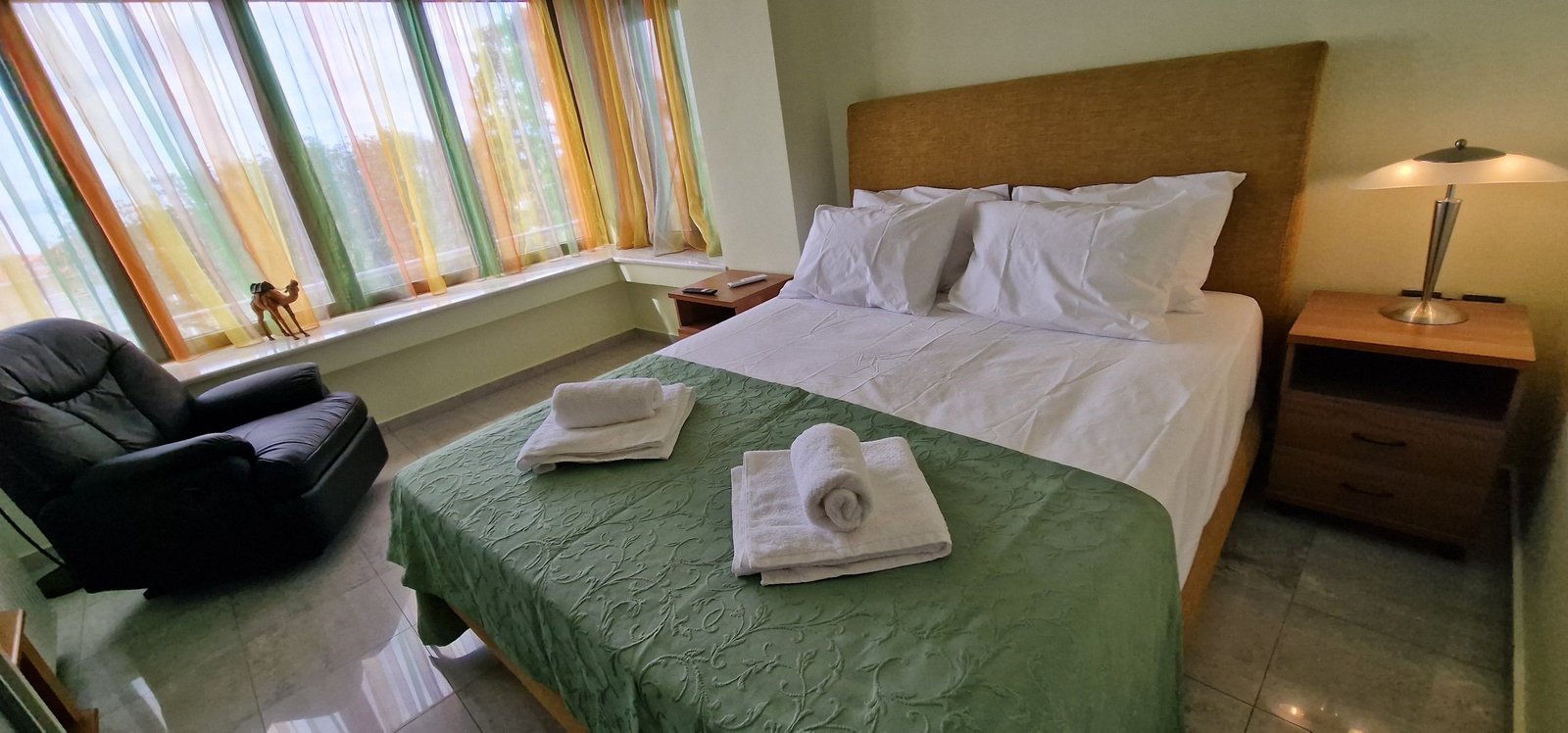 Υπνοδωμάτιο στη Villa Memories στην Κινέτα με διπλό κρεβάτι, πράσινη κουβέρτα και μεγάλο παράθυρο-5