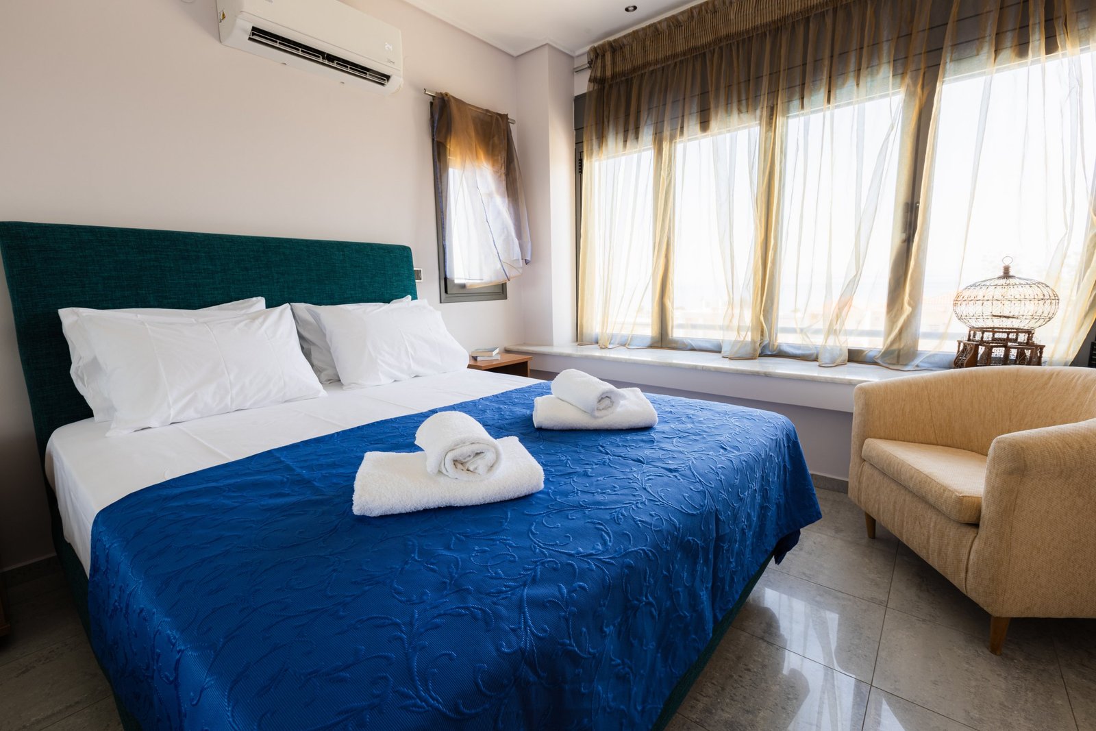 Υπνοδωμάτιο της Villa Memories στην Κινέτα με διπλό κρεβάτι, πολυθρόνα και μεγάλο παράθυρο