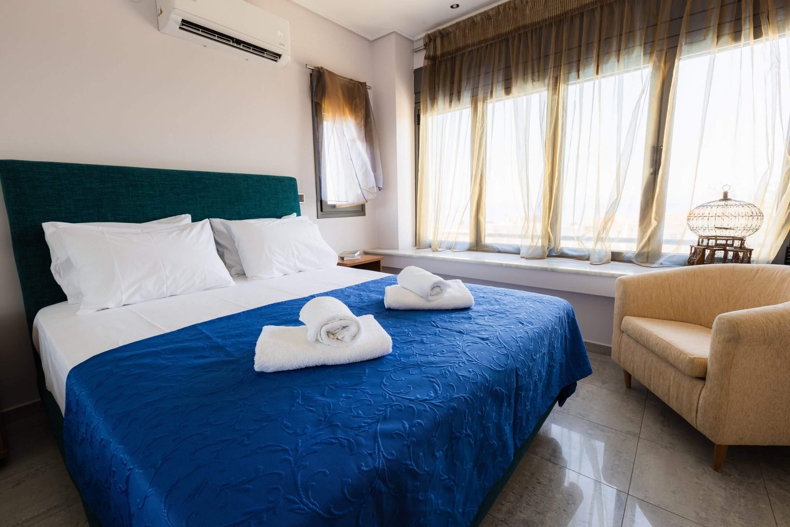 Υπνοδωμάτιο στη Villa Memories στην Κινέτα με διπλό κρεβάτι, μπλε κουβέρτα και φυσικό φως