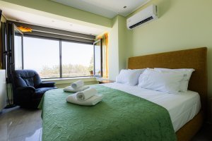 Υπνοδωμάτιο της Villa Memories στην Κινέτα με διπλό κρεβάτι και πράσινο κάλυμμα κρεβατιού