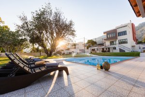 Ιδιωτική πισίνα της Villa Memories κατά το ηλιοβασίλεμα με θέα τη βίλα