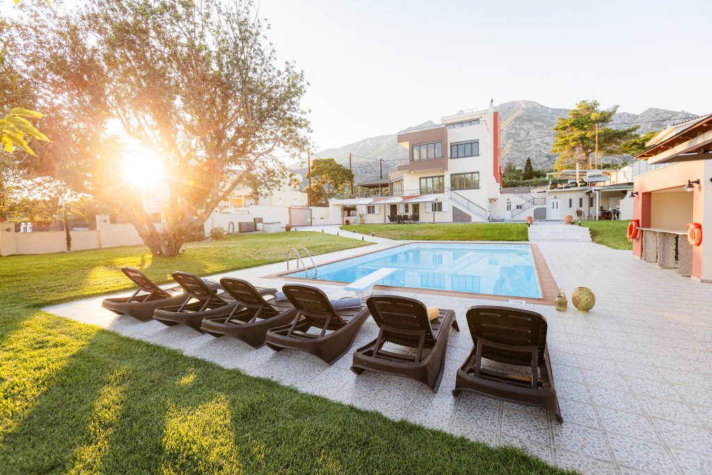 Ιδιωτική πισίνα της Villa Memories κατά το ηλιοβασίλεμα με ζεστό φως