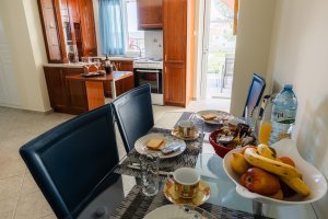 Τραπεζαρία της Villa Memories με πρωινό, φρούτα και θέα προς την κουζίνα