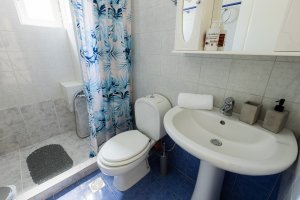 Μπάνιο της Villa Memories με ντους, νιπτήρα και μπλε πλακάκια