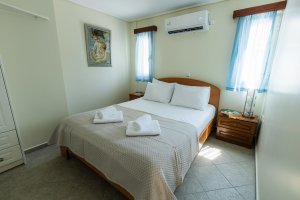 Φωτεινό υπνοδωμάτιο της Villa Memories με διπλό κρεβάτι και λευκά σεντόνια