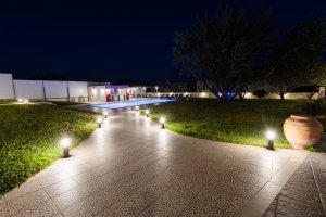 Πέτρινος διάδρομος με φωτιστικά στον κήπο της Villa Memories στην Κινέτα τη νύχτα