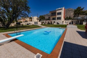 Σκεπασμένο εξωτερικό καθιστικό της Villa Memories με καρέκλες και θέα στην πισίνα