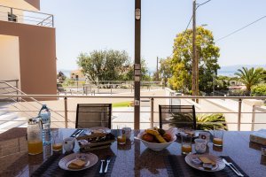 Πρωινό σε εξωτερική τραπεζαρία της Villa Memories με θέα θάλασσα και κήπο