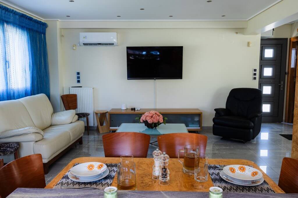 Εσωτερικός χώρος καθιστικού και τραπεζαρίας στη Villa Memories στην Κινέτα με άνετα έπιπλα