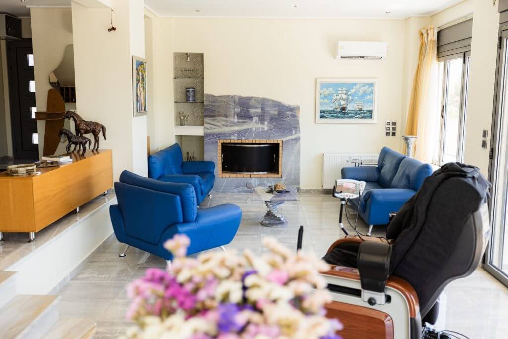 Καθιστικό της Villa Memories στην Κινέτα με τζάκι και άνετους καναπέδες