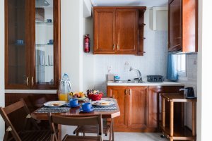 Πλήρως εξοπλισμένη κουζίνα της Villa Memories με ξύλινα ντουλάπια και τραπέζι φαγητού