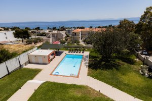 Ιδιωτική πισίνα της Villa Memories με ξαπλώστρες και πράσινο κήπο